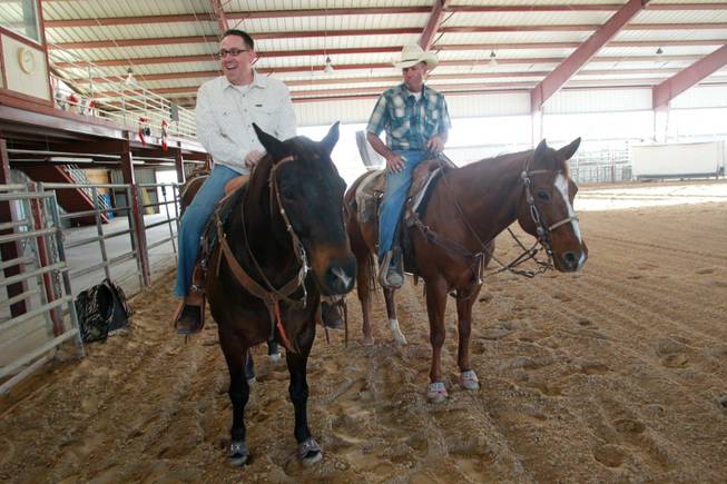 Las Vegas Sun sports editor Ray Brewer laughs while UNLV rodeo coach Ric Griffith helps him ride Anson Nov. 2, 2012.